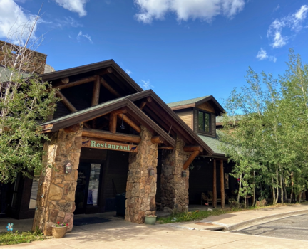 Summer trips call for snacks at the Trailhead Restaurant. Image shows a log cabin and rock style restaurant.