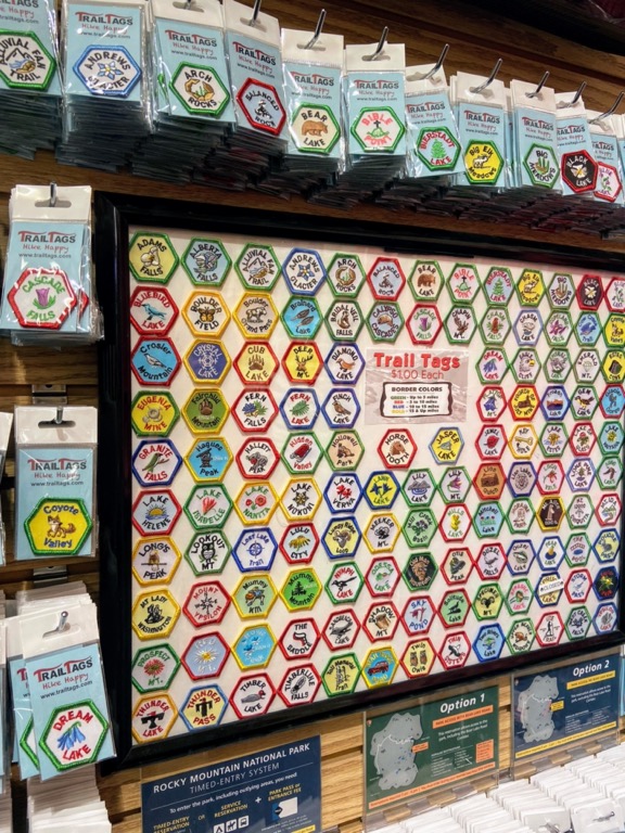image shows a bulletin board with embroidered patches for different hikes at Rocky Mountain National Park.