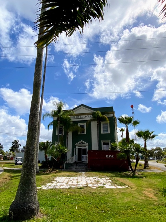 image shows Bank of Everglades a historic two story building surrounded by palm trees