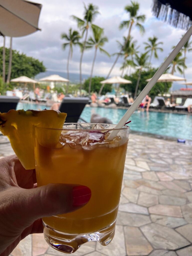 image shows a mai tai drink by a pool