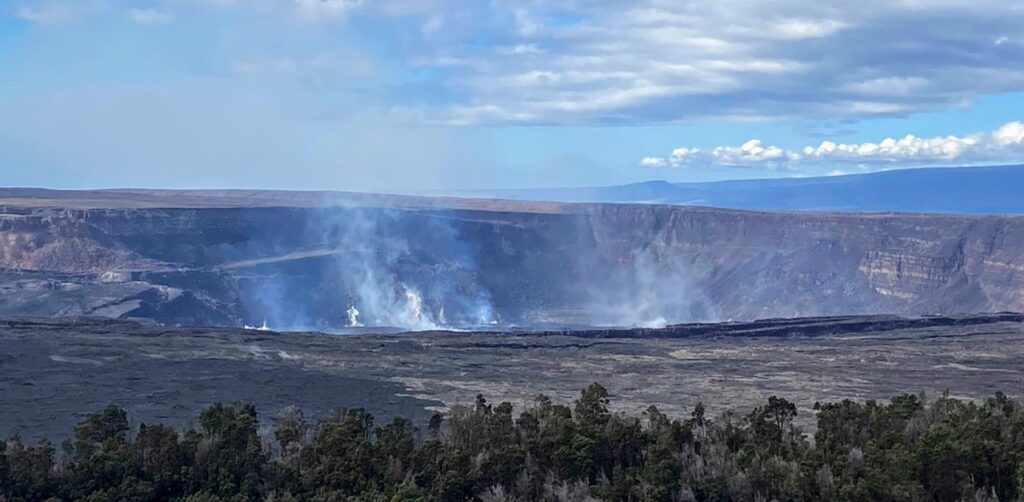 image shows Kilauea Crater with steam from active lava