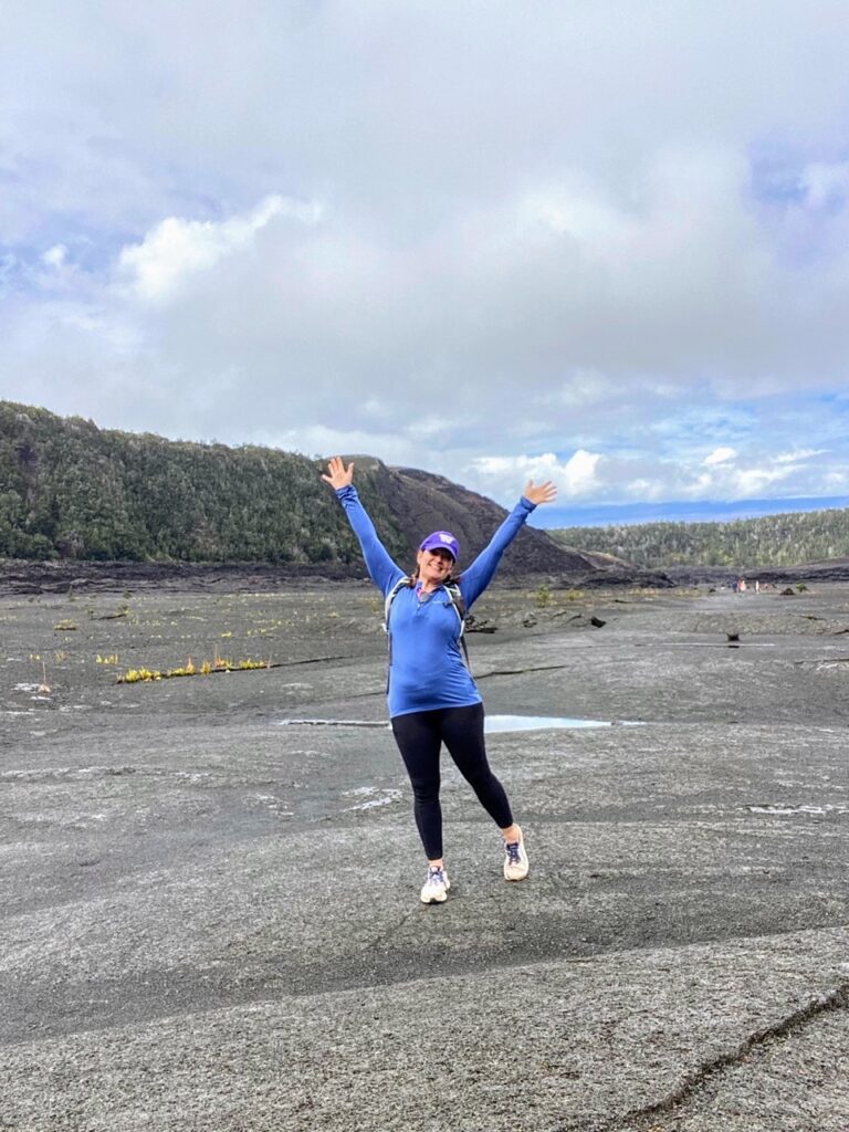 image shows a woman in a periwinkle shirt on a crater, part of a five day itinerary focused on national parks on the Big Island of Hawaii