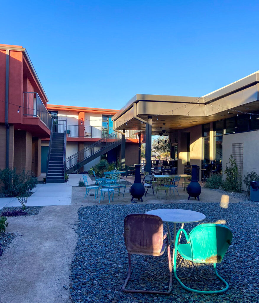 image shows a courtyard of a hotel with outdoor lawn chairs and gravel