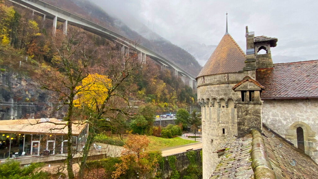 a medieval castle with a raised rail line in the background, in a foggy fall setting in lausanne