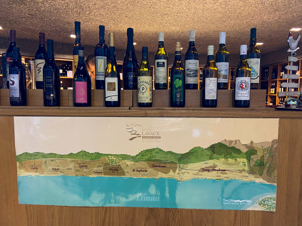 image shows eighteen bottles of wines on a counter, below is a map of the lavaux vineyard region. the vinorama building is open in the winter