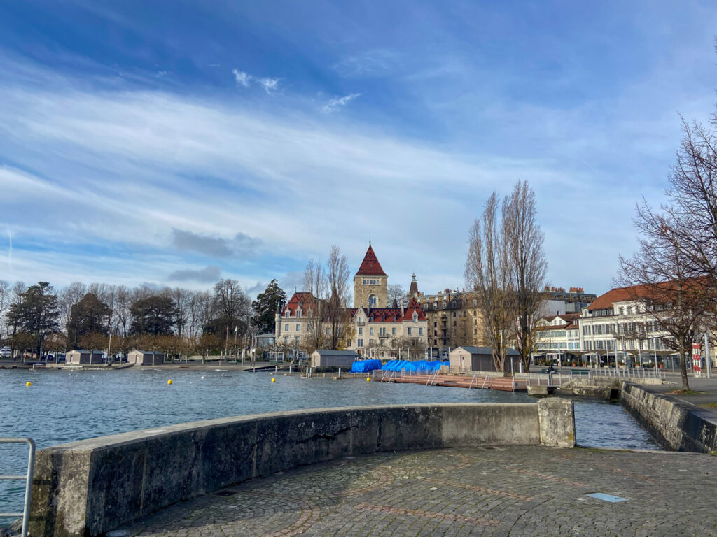 a european-looking town sits on the edge of a lake geneva in lausanne, which is quiet in the winter when you visit