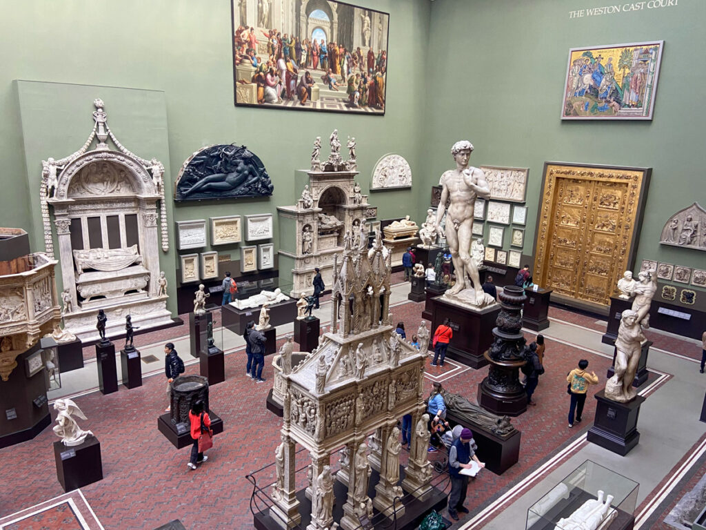 image is taken from a balcony in a museum at the V&A showing the Cast Courts gallery of plaster casts