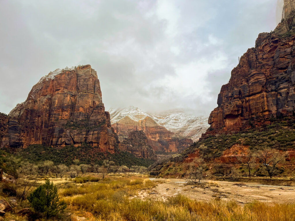 the canyon walls of zion against a gray stormy sky